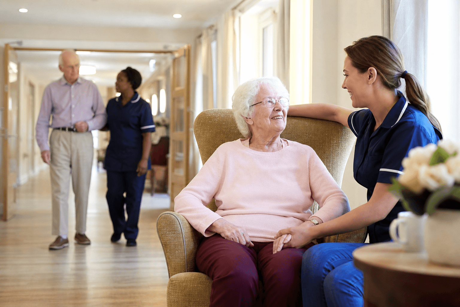 Nurses and carers with residents in a UK nursing home corridor