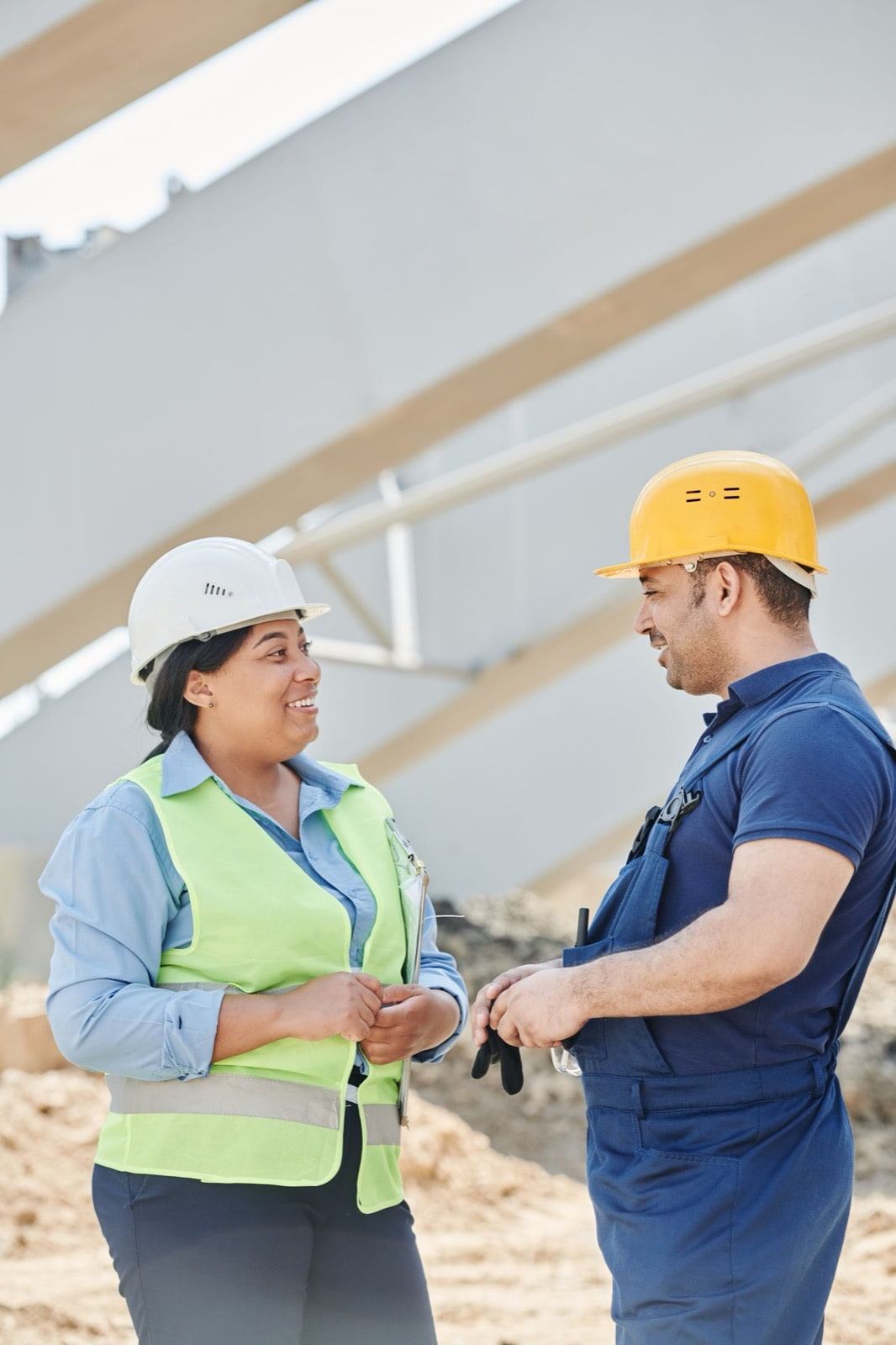 Construction site managers in hard hats and hi-vis vests coordinating on site